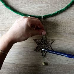 étoile en bois et grelot fixé à un cercle en métal