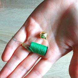 bobine de fil de couture vert et grelot